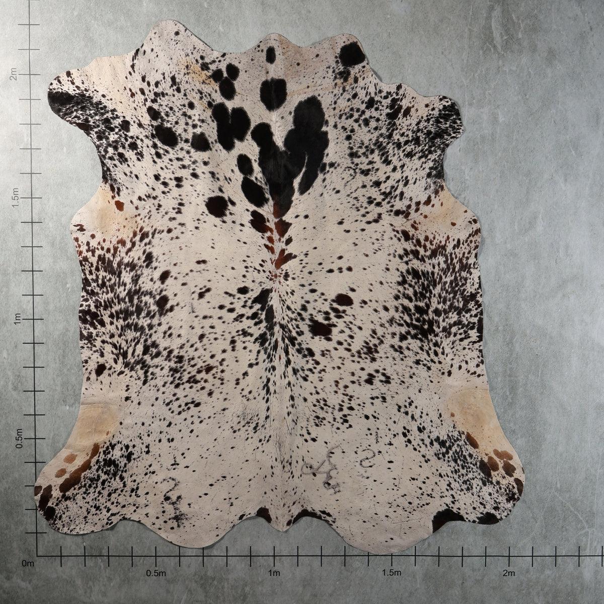 White and black speckled Nguni hide with bold dark patches and scattered brown spots, genuine South African cowhide – AAS8335.