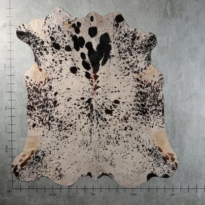 White and black speckled Nguni hide with bold dark patches and scattered brown spots, genuine South African cowhide – AAS8335.