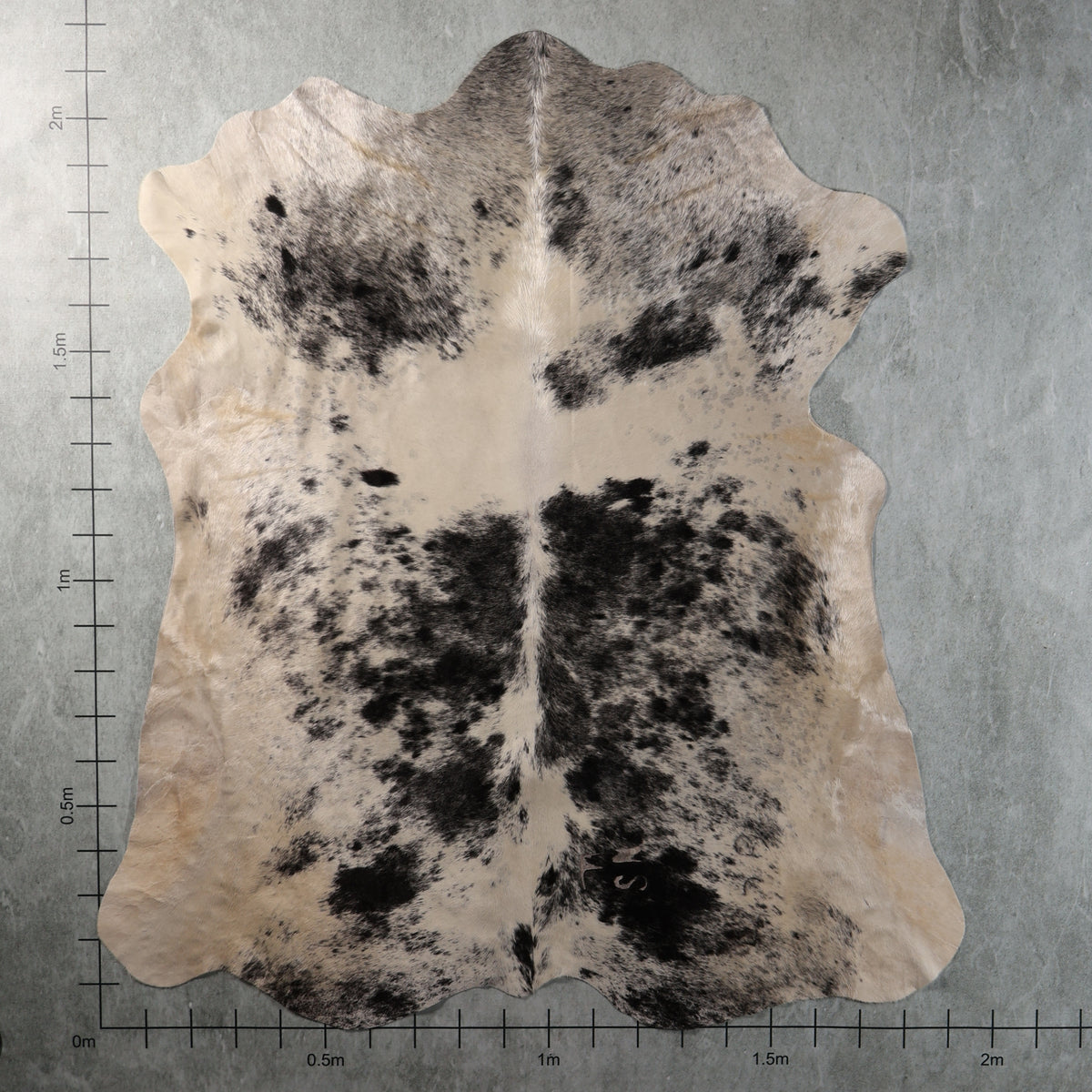 Cream and black mottled Nguni hide with irregular dark patches and fine grey-black speckling, genuine South African cowhide – AAS8342.