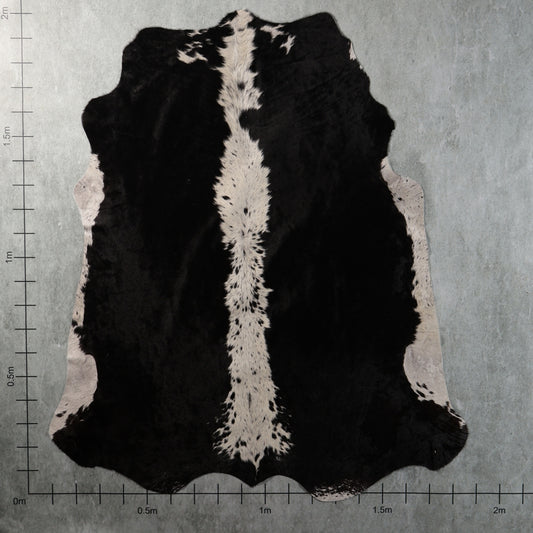 Genuine South African black-and-white Nguni cowhide with bold black panels, a distinctive white speckled central stripe and contrasting white side markings – BGS2750.