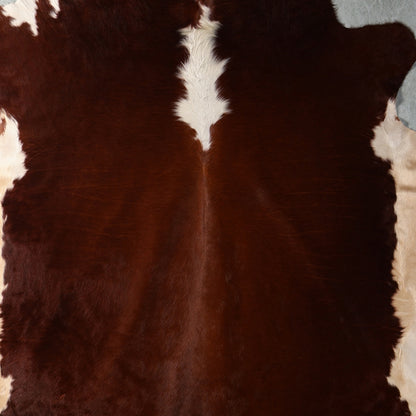 A Close up of a brown and white cowhide rug.