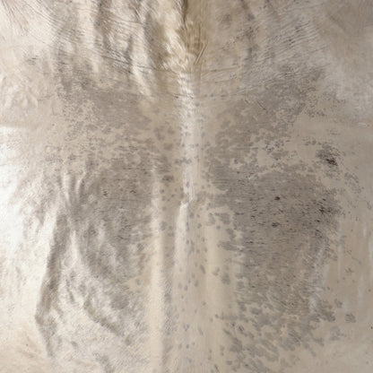 A close-up of a Nguni cowhide rug showing a natural mottled pattern in cream, beige, and gray tones
