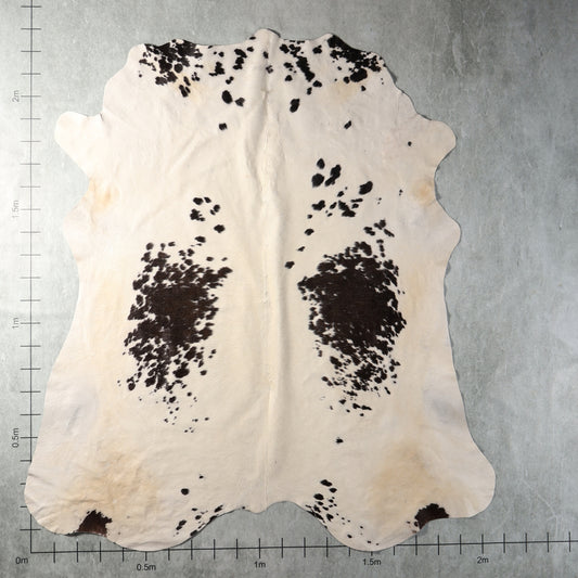 Genuine South African Nguni hide AGD7187 in cream and dark brown with two prominent speckled patches and scattered spots.