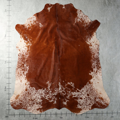 Genuine South African Nguni hide AGS7403 in rich reddish chestnut brown with white speckled edges and natural mottling.