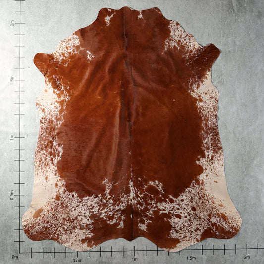 Genuine South African Nguni hide AGS7403 in rich reddish chestnut brown with white speckled edges and natural mottling.