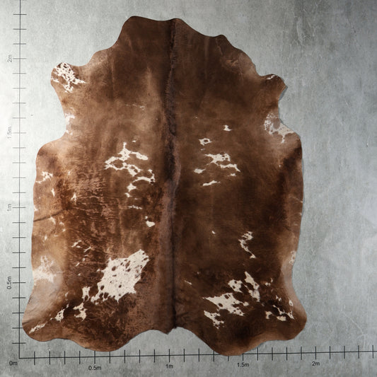 Genuine South African Nguni hide AGS7406 in chocolate brown with irregular white patches and warm natural brown tones.