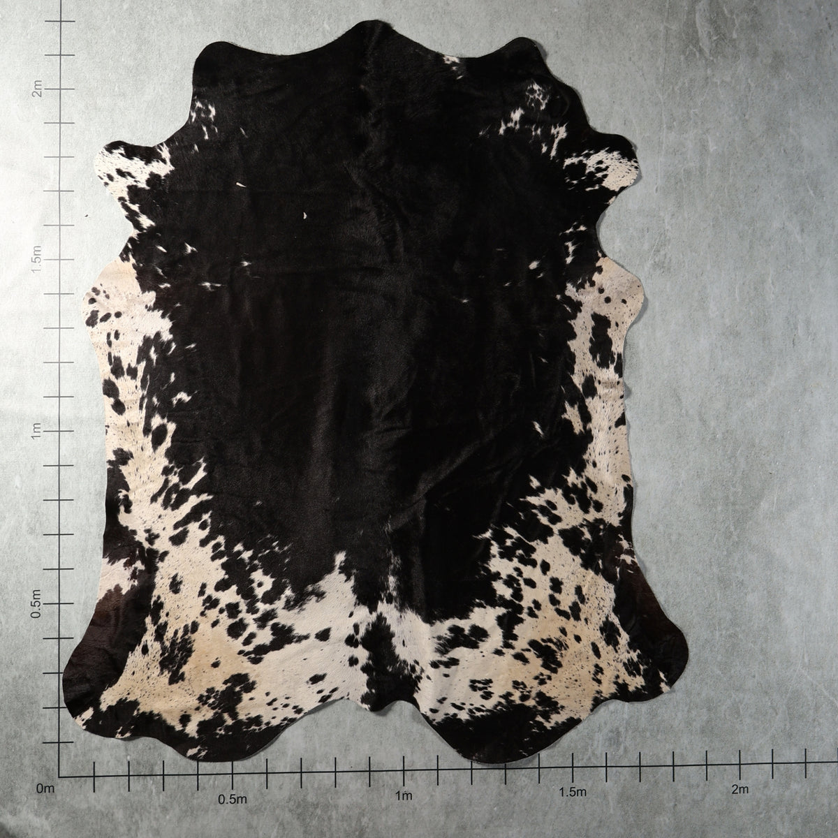 Black and white speckled genuine South African Nguni cowhide AGS7414 with a large solid black centre and spotted white edges.