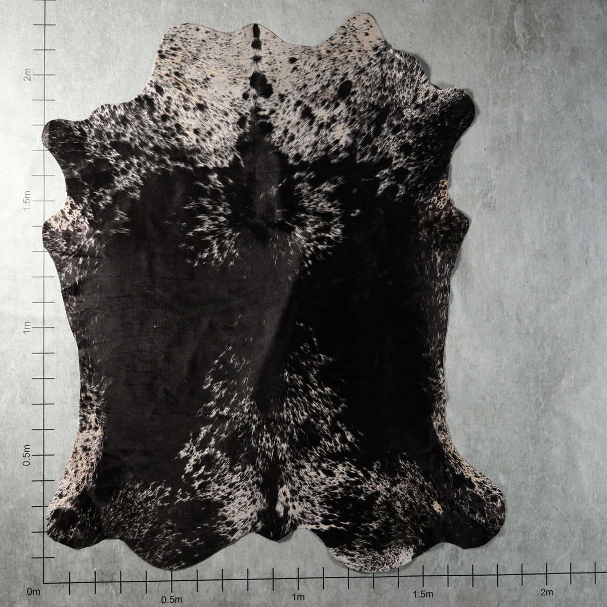 Black and white densely speckled genuine South African Nguni cowhide AGS7420 with bold black patches and intricate spotted markings.