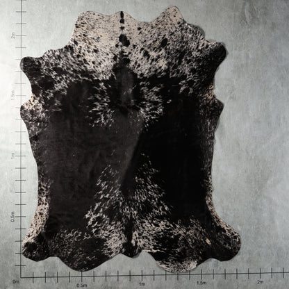 Black and white densely speckled genuine South African Nguni cowhide AGS7420 with bold black patches and intricate spotted markings.