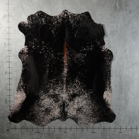 Genuine South African black-and-white speckled tri-colour Nguni hide with a distinctive reddish-brown central streak and finely mottled markings – TRI2856.